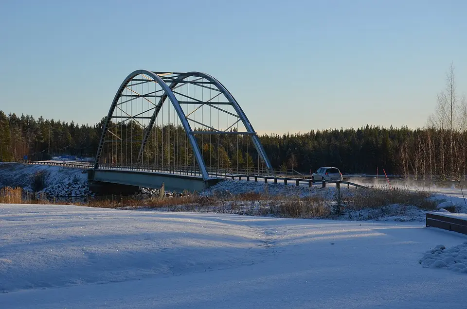 Bil på väg över bron vid Luleälven i snö
